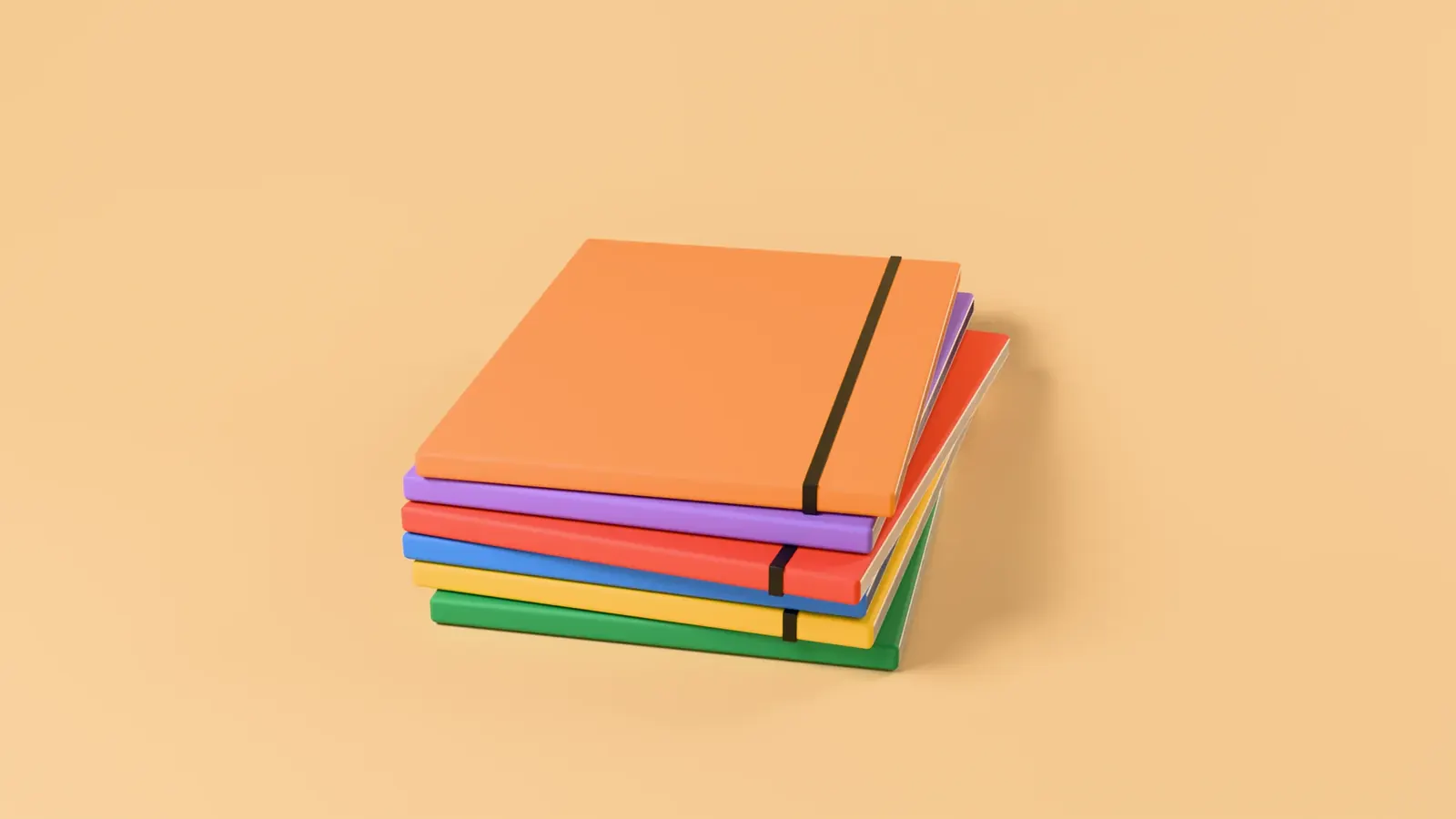 A stack of Fieldnote notebooks in six colours on a warm set